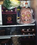 A plastic skull covered with Jello and cold cuts wrapped with plastic wrap